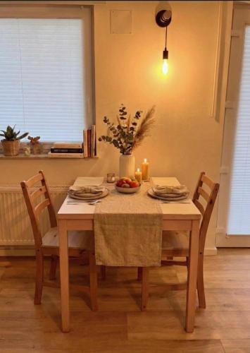 a dining room table with two chairs and a table with candles at Wohlfühlapartment GUXHAGEN- nähe Bahnhof & A7, schnell in Kassel in Guxhagen