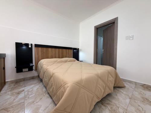 a bedroom with a bed and a flat screen tv at Apart Continente Park in San Clemente del Tuyú