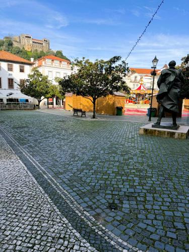a statue of a man sitting on a stone street at Art Apartments Leiria Historic House in Leiria