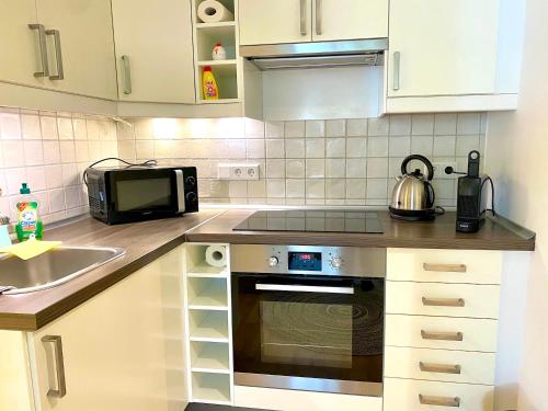 a kitchen with a sink and a stove top oven at Ferienwohnung Kirchbichl am Schliersee mit Terrasse in Schliersee