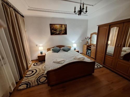a bedroom with a bed and a chandelier at Bieszczadzka Chata Stańkowa in Ropienka