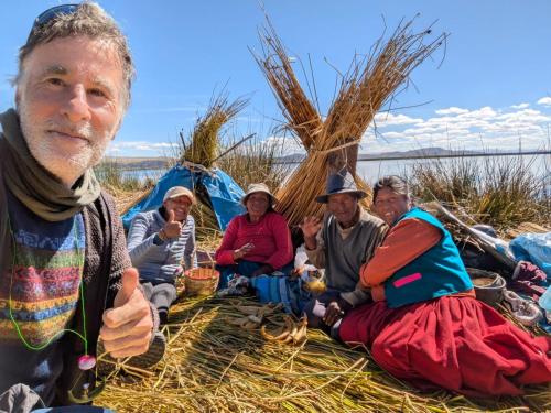 a group of people sitting in front of tents at Casa de Yolanda en Uros in Puno