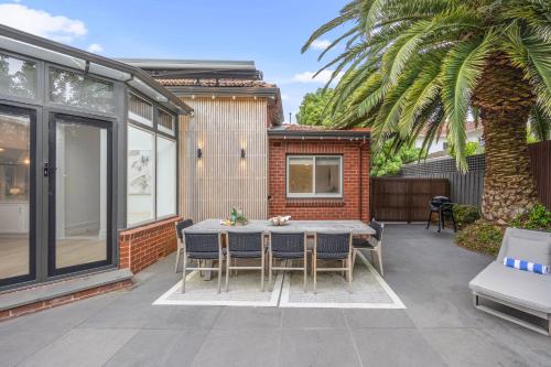 a patio with a table and chairs and a house at Complete Host Brighton House in Melbourne