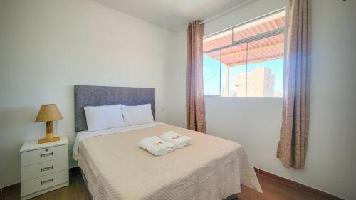 ein Schlafzimmer mit einem Bett, auf dem zwei Handtücher liegen in der Unterkunft Mary 2 in Paracas