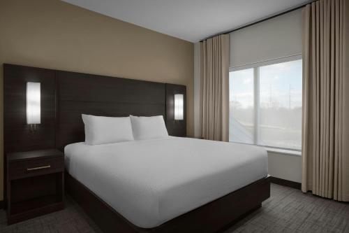 a bedroom with a large bed and a large window at Residence Inn by Marriott Newark, DE in Newark