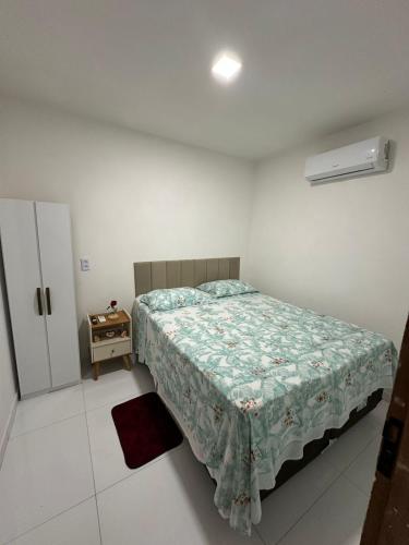 a small bedroom with a bed and a night stand at Flat JK em Dona Inês-pb in Dona Inês