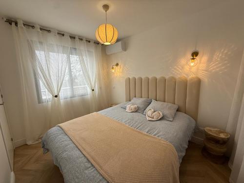a bedroom with a bed with two towels on it at Le Balcon petit extérieur Idéal familles & couples à 10 min Disneyland Paris avec lit Queen size & parking privé in Coupvray