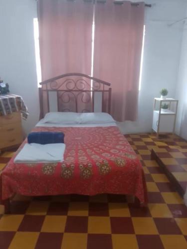 una camera da letto con un letto con un piumone rosso di Salerno a Chiclayo