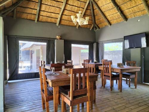 a dining room with wooden tables and chairs at Sofitel Inn in Maun