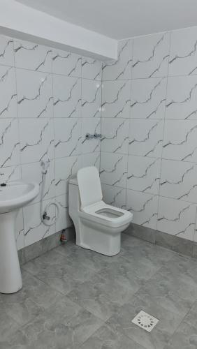 a bathroom with a toilet and a sink at MH Zanzibar in Jambiani