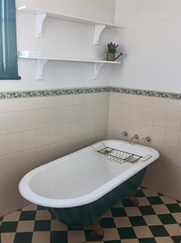 a bath tub in a bathroom with a tiled floor at Woodhill Way Burra in Burra