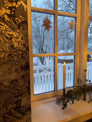 a window with a candle and a fence and snow at Lund gamle skole - tæt på MCH in Herning