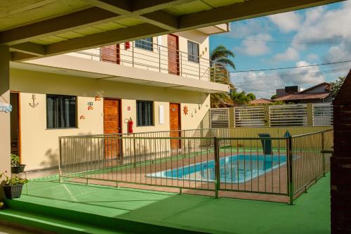 a house with a swimming pool in front of a house at Pousada Iza in Salinópolis