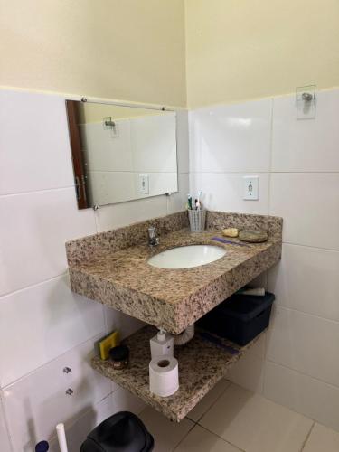 a bathroom counter with a sink and a mirror at Casinha da Canastra in Delfinópolis