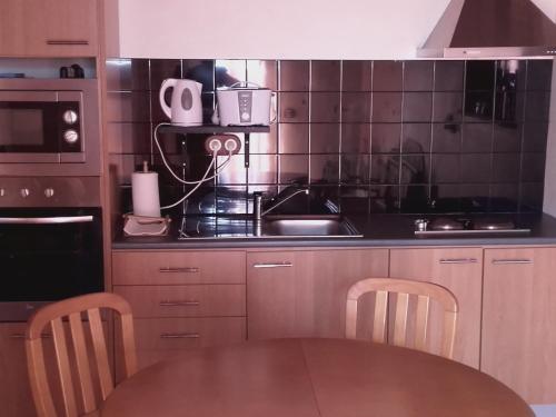 a kitchen with a table and a stove top oven at Adega Ramalho in Canto da Areia