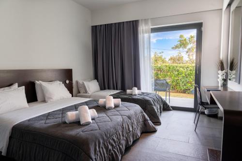 a hotel room with two beds and a window at Megara Hotel in Megara