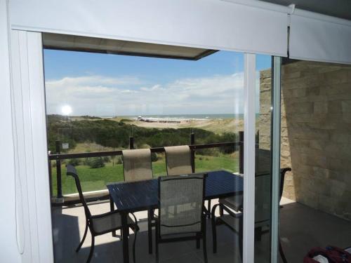 un tavolo e sedie su un balcone con vista sull'oceano di Linda Bay Playa a Mar de las Pampas