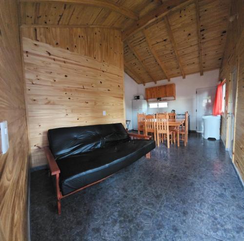 a black couch in a room with a dining room at Yacaré INN in Ituzaingó