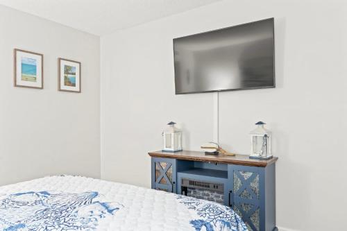 a bedroom with a bed and a tv on a wall at Golf Glenn Villa A205 in Myrtle Beach