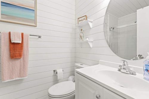a white bathroom with a toilet and a sink at Golf Glenn Villa A205 in Myrtle Beach