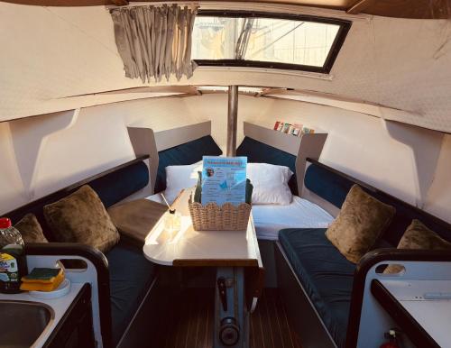 a small boat with a couch and a table in it at Deolinda Charming Boat Stay at Oriente Marina in Lisbon