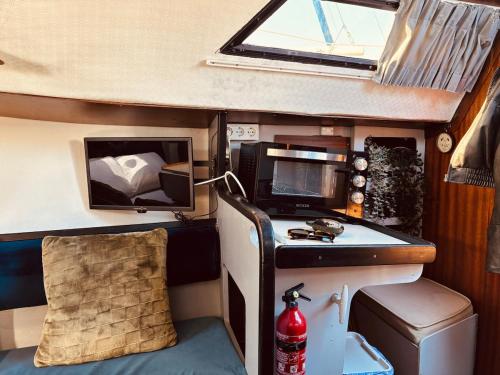 a small room with a desk and a tv at Deolinda Charming Boat Stay at Oriente Marina in Lisbon