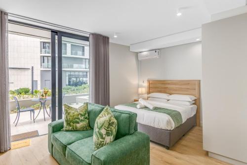 a bedroom with a bed and a green couch at Ellipse Soleya in Midrand