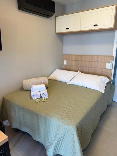 a bedroom with a bed with two towels on it at Eco Green Container- Guarda do Embaú SC in Palhoça