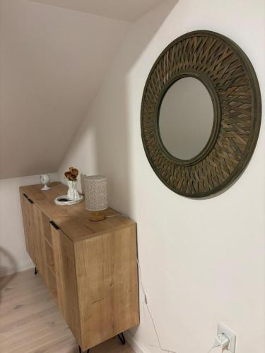 a mirror on a wall next to a wooden dresser at Duplex House - Private Home MUNA in Sarajevo