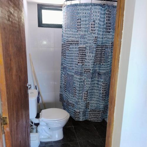 a bathroom with a toilet and a shower curtain at Departamento 8 in El Bolsón