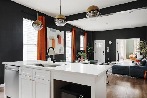 a kitchen with a sink and a living room at Indy Getaway - Near Downtown Indy - Sleeps 10! in Indianapolis