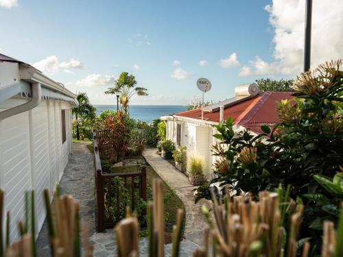 a garden with plants and the ocean in the background at Bungalow Brise Marine - Plaisir d Évasion in Deshaies