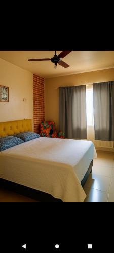 a bedroom with a large bed and a ceiling fan at casas praias familiar in Piçarras