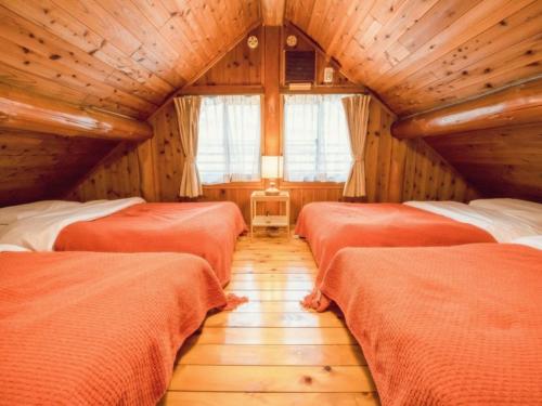 a room with three beds in a wooden room at ザランタン鹿沼 in Kanuma