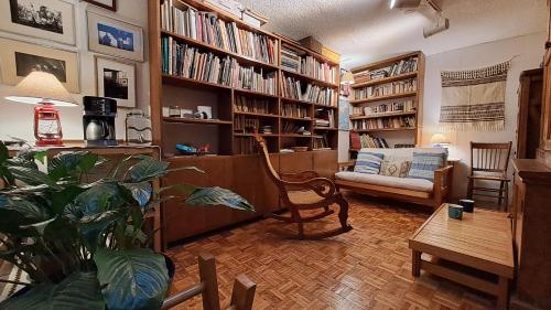 a living room with a couch and a chair and books at Cuarto baño sala San Angel cerca de ITAM UNAM Bazar Sábado in Mexico City