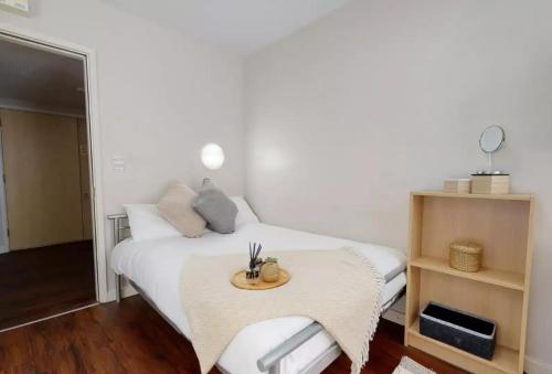 a bedroom with a white bed with a table at Tufnell House in London in London