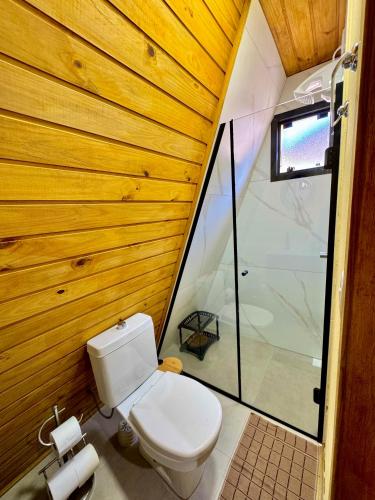 a small bathroom with a toilet and a shower at Chale do Boni in Palhoça