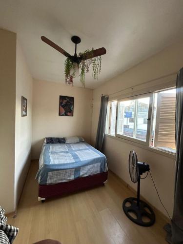 a bedroom with a bed and a ceiling fan at Casa temporada SG in São Gabriel