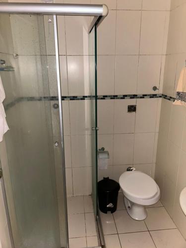 a bathroom with a toilet and a glass shower at Casa temporada SG in São Gabriel