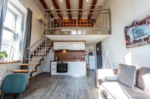 a living room with a couch and a kitchen and a staircase at The LOFT Ljubljana in Ljubljana