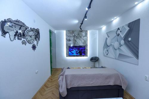 a bedroom with a bed and a painting on the wall at GAMA Apartments in Bitola