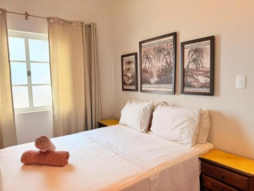a bedroom with a bed with a teddy bear on it at Apartamento Central em Araxá in Araxá