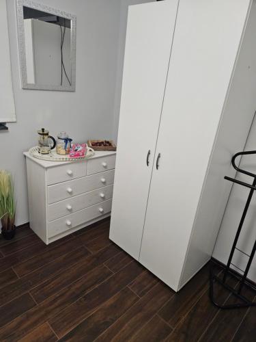 a white cabinet and a dresser in a room at Luxus Apartman in Szombathely