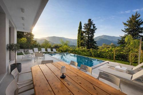 a house with a pool and a table and chairs at Villa Harmony Luxury Resort in Corfu
