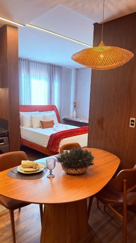 a room with a table and a bed and a bedroom at Flat Vinhedo in Montes Claros