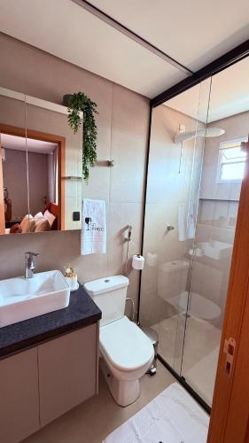a bathroom with a toilet and a sink and a shower at Flat Vinhedo in Montes Claros