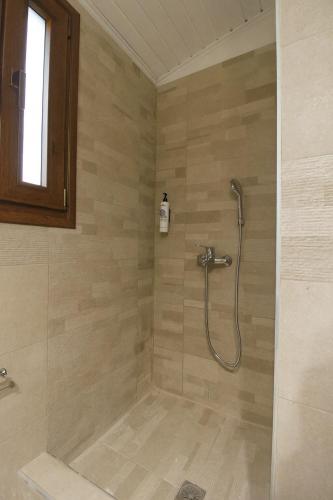 a bathroom with a shower with a shower head at Raise Polydrosos Traditional Getaway in Polydrossos