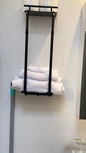 a black towel rack with white towels on a wall at De Drie Populieren in Losser