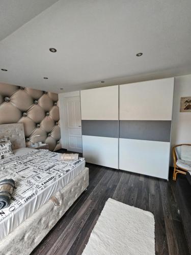 a bedroom with a large bed with a padded headboard at Luxus Apartman in Szombathely