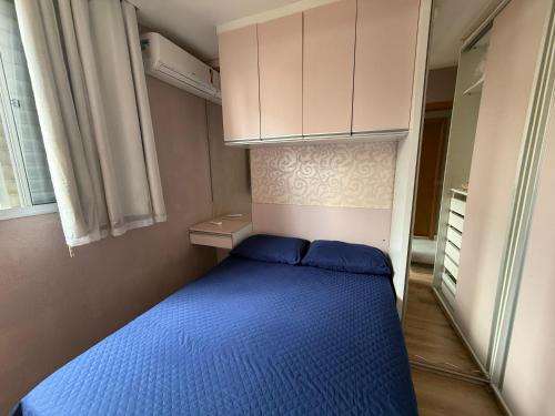 a small bedroom with a blue bed and white cabinets at Doce lar da Be in Ribeirão Preto